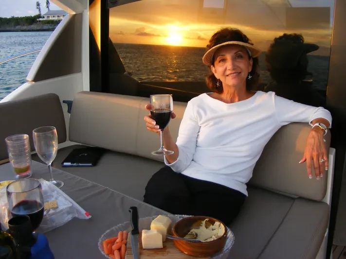  Yacht Photos Pics Woman enjoying wine and snacks on a 2012 Prestige 440S yacht at sunset.