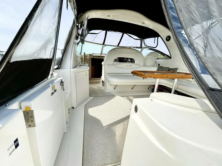  Yacht Photos Pics Interior view of 2000 Sea Ray 410 Sundancer yacht, featuring seating and a wooden table.