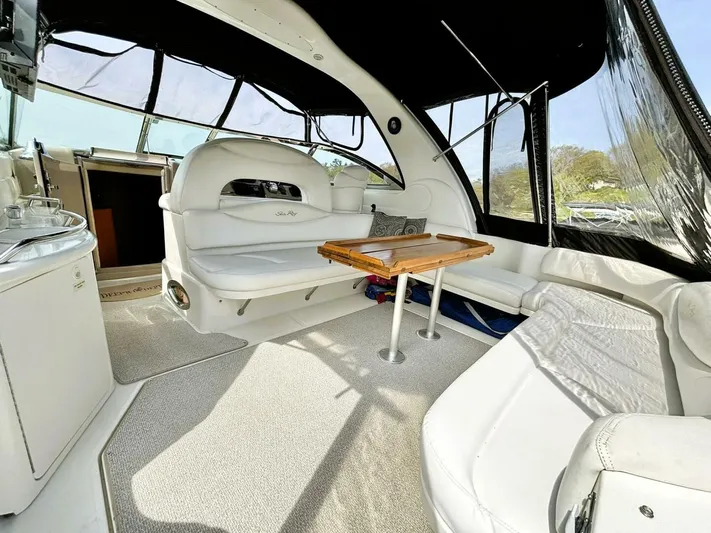  Yacht Photos Pics Interior of 2000 Sea Ray 410 Sundancer yacht with white seating and wooden table.