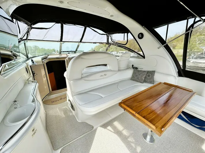  Yacht Photos Pics Luxurious interior of 2000 Sea Ray 410 Sundancer yacht with white seating and wooden table.