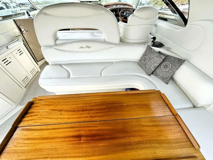  Yacht Photos Pics Luxurious interior of 2000 Sea Ray 410 Sundancer with white seating and wooden table.