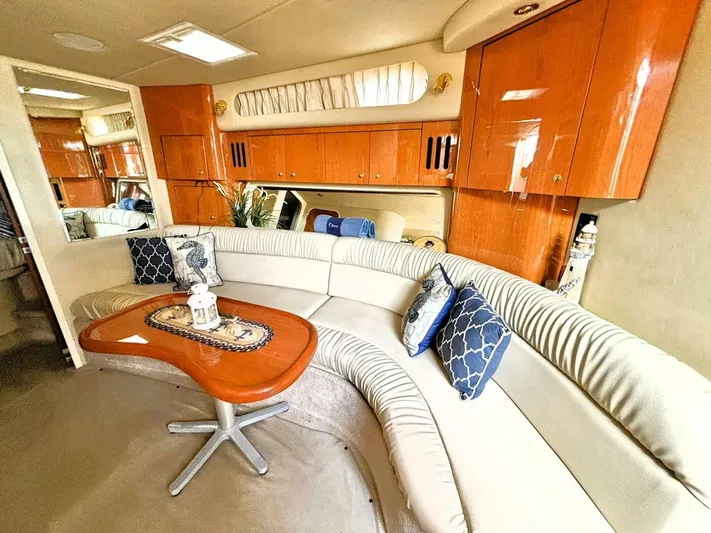  Yacht Photos Pics Luxurious interior of 2000 Sea Ray 410 Sundancer with curved seating and elegant wood finishes.