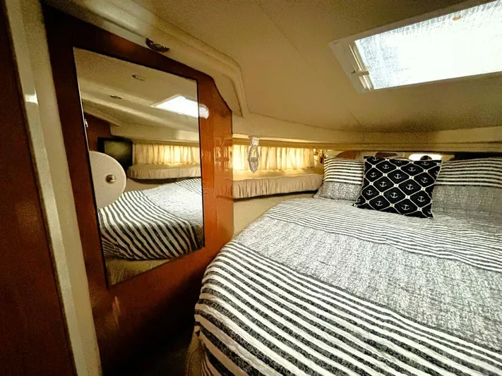  Yacht Photos Pics Cozy cabin interior of 2000 Sea Ray 410 Sundancer with striped bedding and nautical decor.