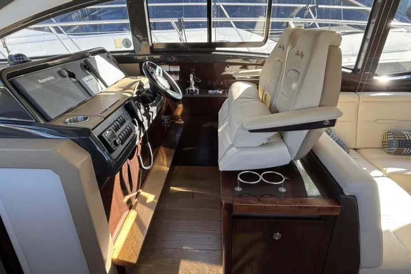 Seven Stars Yacht Photos Pics Interior of 2016 Sea Ray 400 Sundancer yacht with helm and seating area.