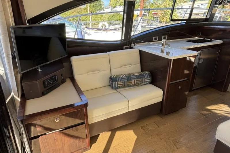 Seven Stars Yacht Photos Pics Luxurious interior of 2016 Sea Ray 400 Sundancer yacht with sofa, TV, and kitchenette.