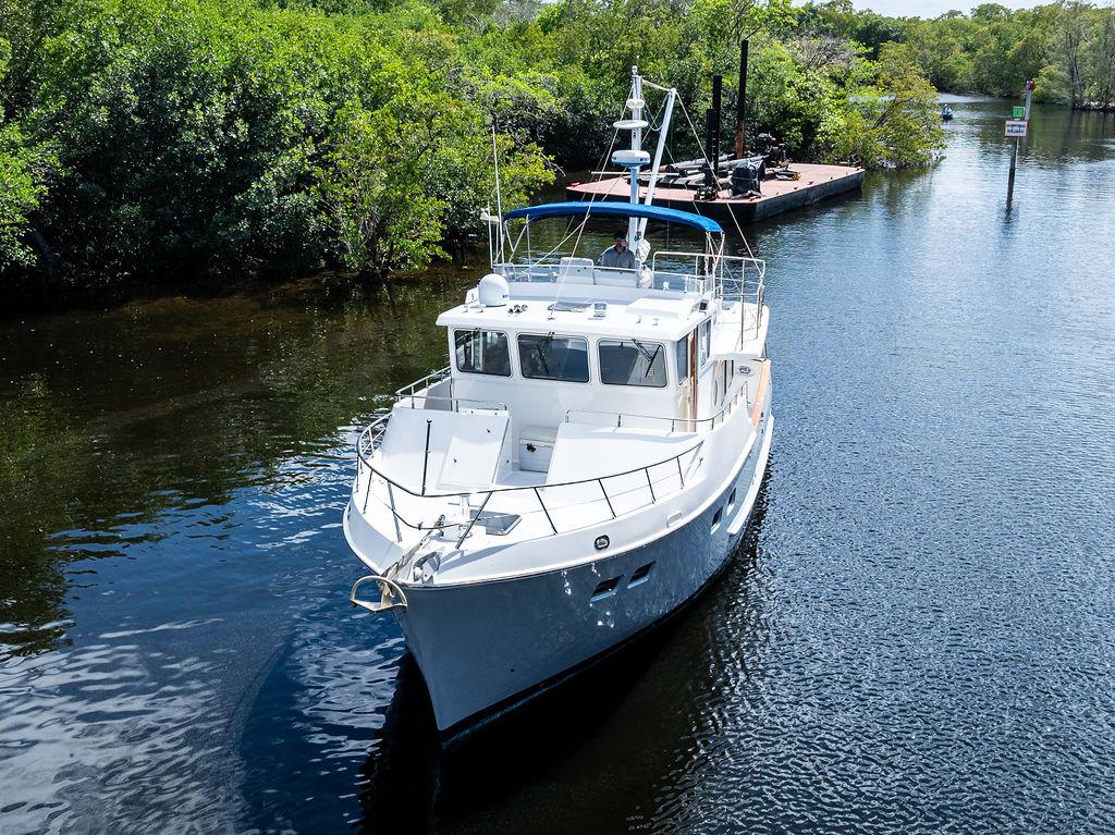 Selene Solo 2000 yacht cruising on a serene river surrounded by lush greenery.