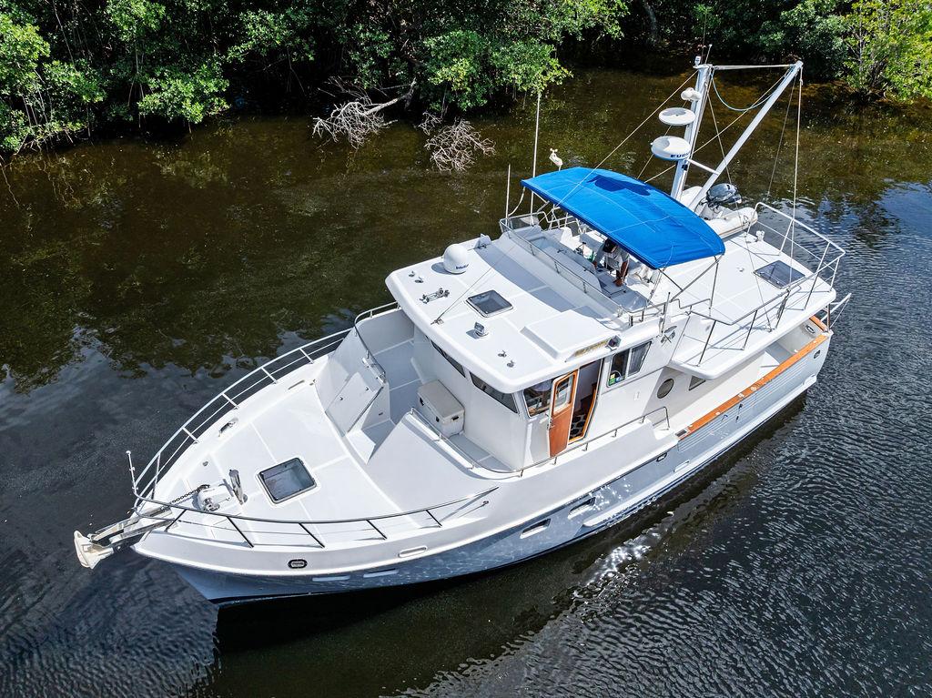 Selene Solo 2000 yacht with blue canopy cruising on a calm river.