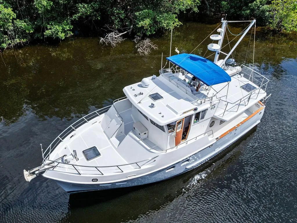 Selene Solo 2000 yacht with blue canopy cruising on a calm river.