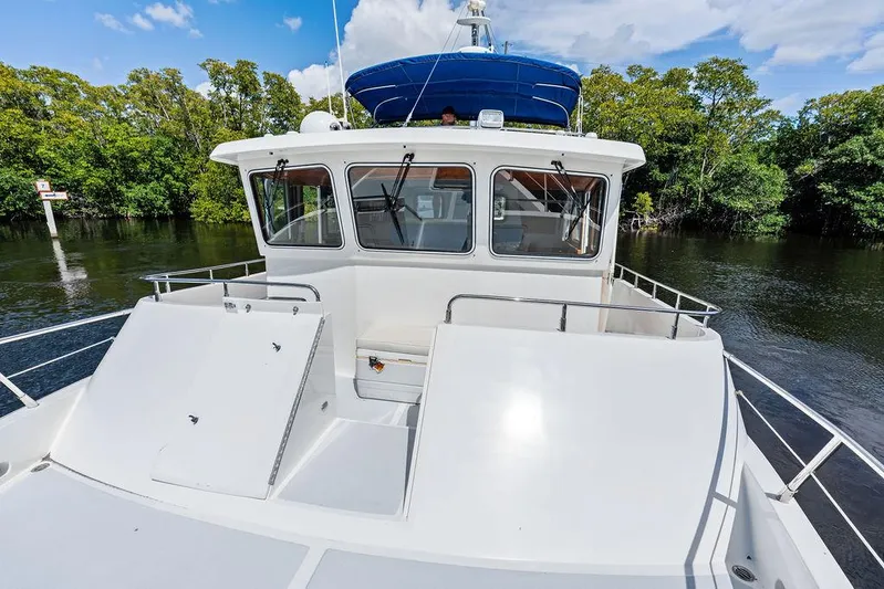  Yacht Photos Pics Selene Solo 2000 boat on calm water, surrounded by lush greenery and blue sky.