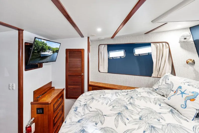  Yacht Photos Pics Cozy bedroom in 2000 Selene Solo yacht with TV, wooden accents, and nautical-themed bedding.