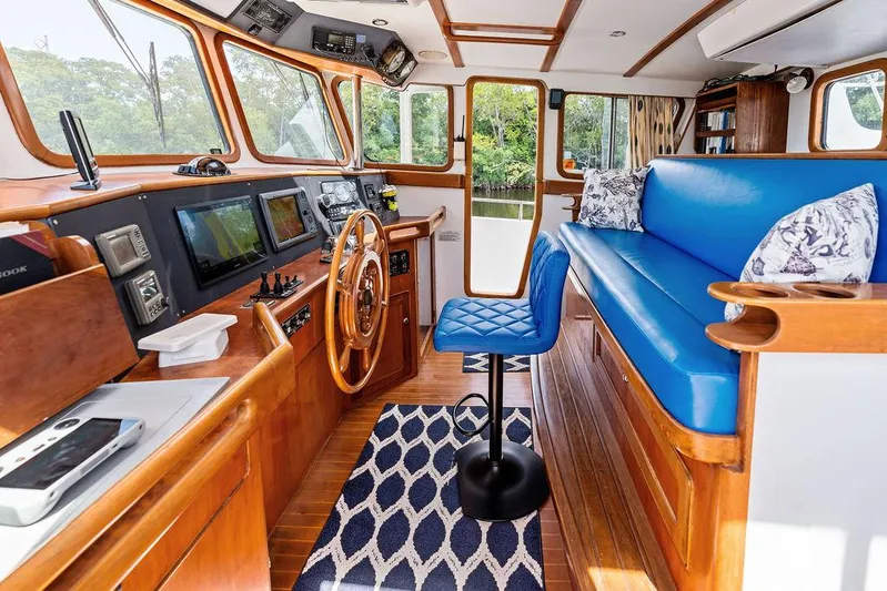  Yacht Photos Pics Interior of 2000 Selene Solo boat with blue seating, wooden helm, and navigation equipment.