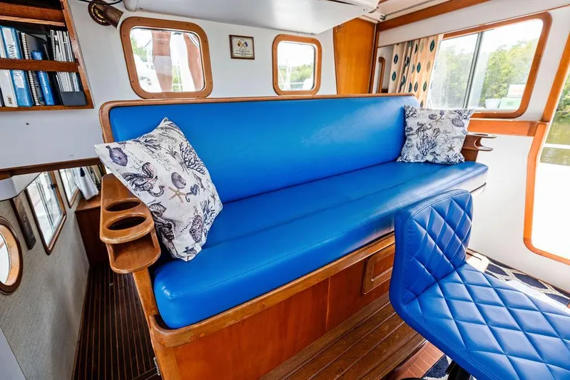  Yacht Photos Pics Cozy interior of 2000 Selene Solo boat with blue seating and decorative pillows.