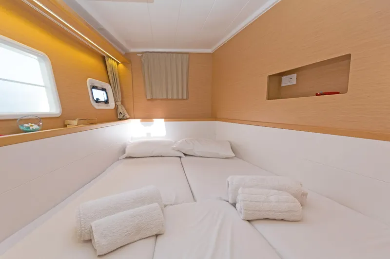  Yacht Photos Pics Cozy cabin interior of 2017 Lagoon 400 S2 yacht with neatly arranged bed and towels.