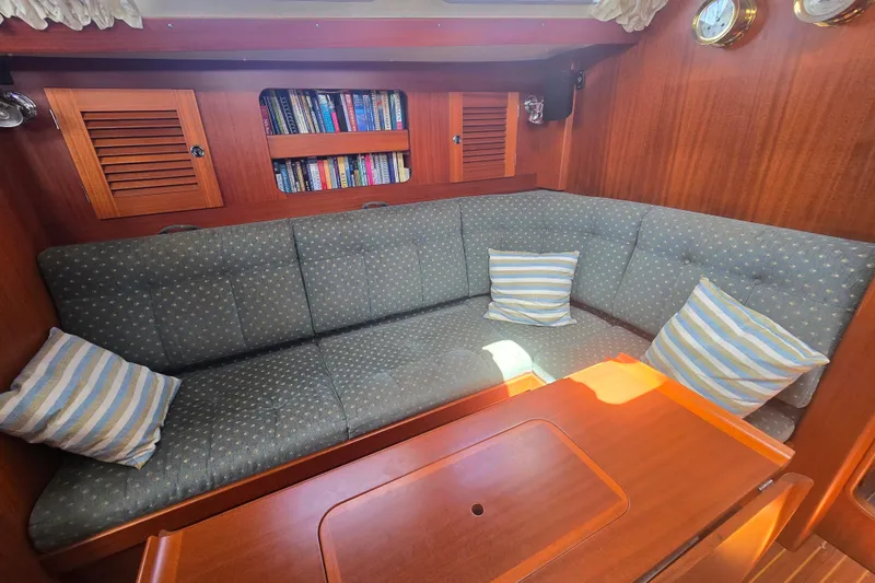 Georgia B Yacht Photos Pics Cozy interior of 2000 Hallberg-Rassy 42F Mk II yacht with cushioned seating and bookshelves.