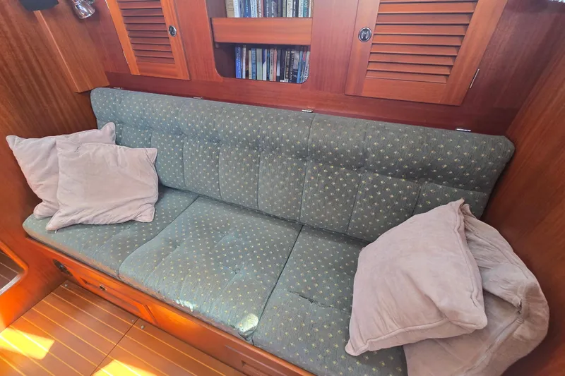 Georgia B Yacht Photos Pics Cozy interior of 2000 Hallberg-Rassy 42F Mk II with cushioned seating and wooden accents.
