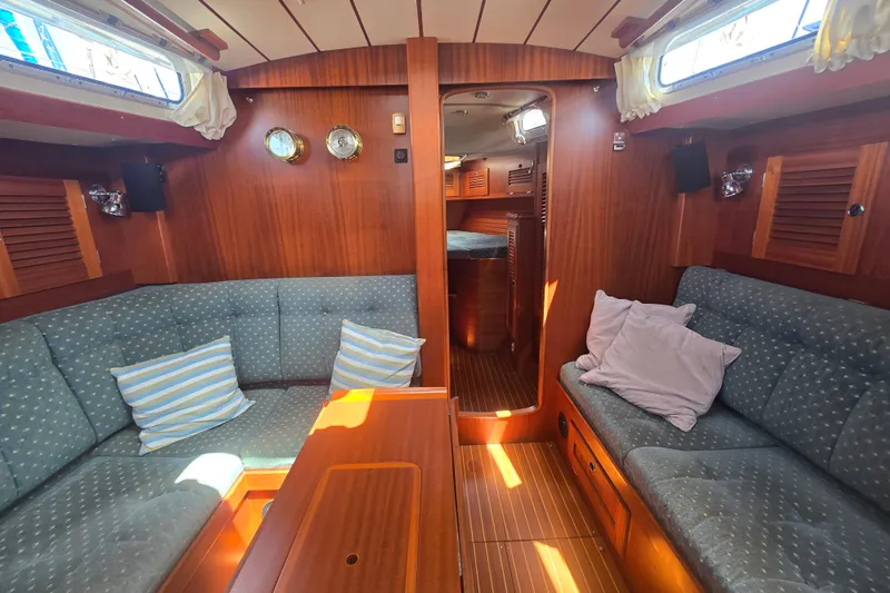 Georgia B Yacht Photos Pics Interior of 2000 Hallberg-Rassy 42F Mk II yacht with cozy seating and wooden finishes.