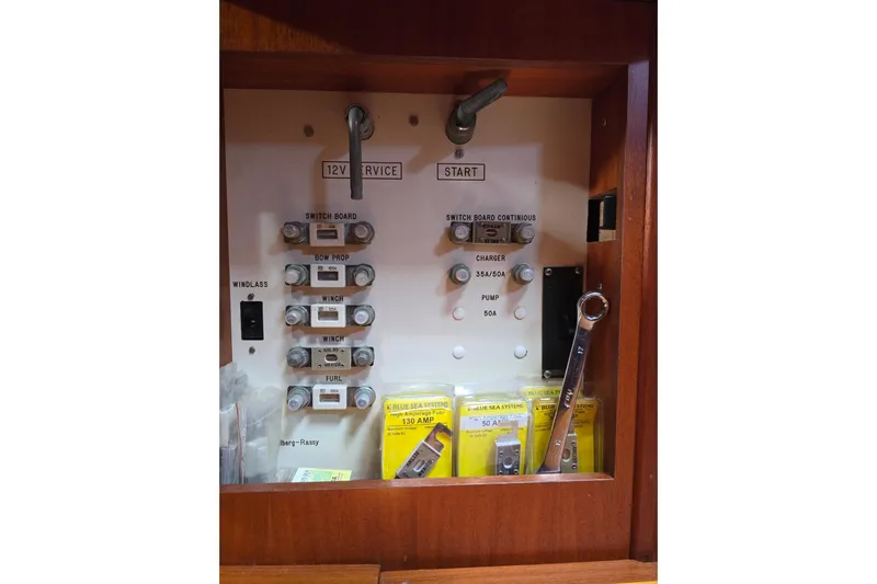 Georgia B Yacht Photos Pics Electrical panel of 2000 Hallberg-Rassy 42F Mk II sailboat with labeled switches and tools.