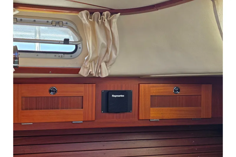 Georgia B Yacht Photos Pics Interior of 2000 Hallberg-Rassy 42F Mk II yacht with wooden cabinets and porthole.