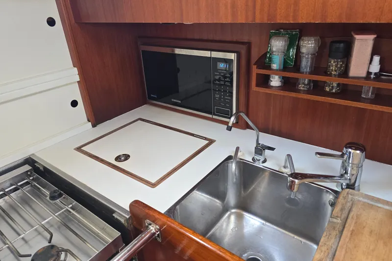Georgia B Yacht Photos Pics Galley kitchen in 2000 Hallberg-Rassy 42F Mk II yacht with sink, stove, and microwave.
