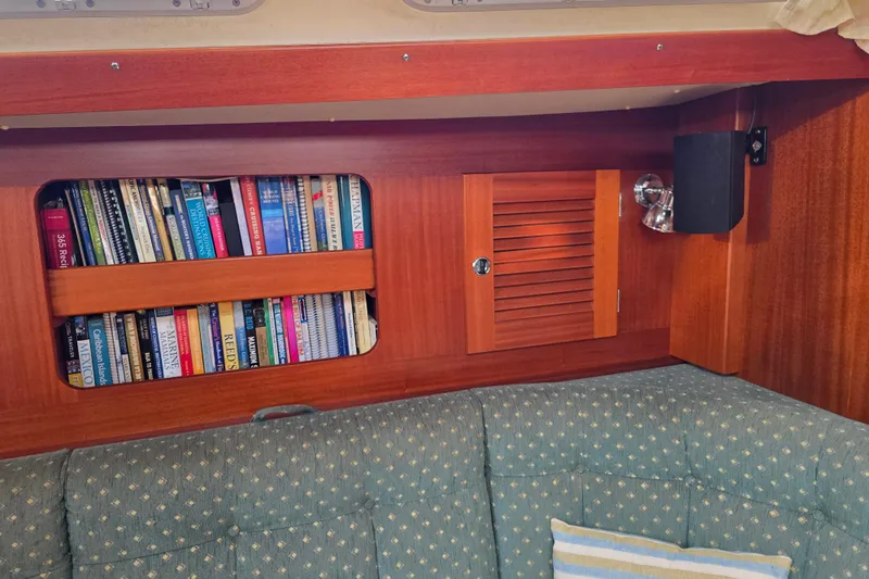 Georgia B Yacht Photos Pics Cozy Hallberg-Rassy 42F Mk II yacht interior with bookshelf and cushioned seating, 2000 model.
