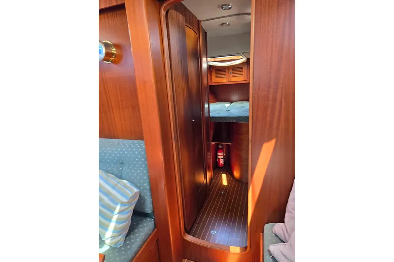 Georgia B Yacht Photos Pics Interior of 2000 Hallberg-Rassy 42F Mk II yacht, featuring wood paneling and cozy cabin.