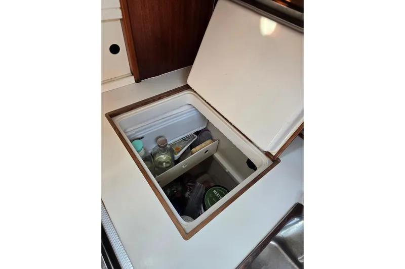 Georgia B Yacht Photos Pics Storage compartment in 2000 Hallberg-Rassy 42F Mk II yacht galley, containing various bottles.