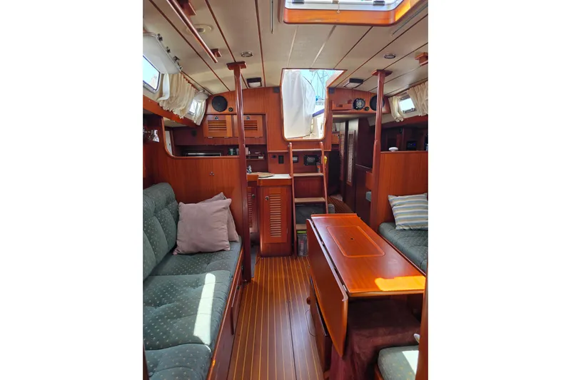 Georgia B Yacht Photos Pics Interior of 2000 Hallberg-Rassy 42F Mk II sailboat with wooden furnishings and cozy seating.