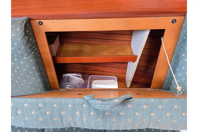 Georgia B Yacht Photos Pics Storage compartment in Hallberg-Rassy 42F Mk II yacht, featuring wooden shelves and containers.