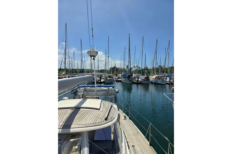 Georgia B Yacht Photos Pics Hallberg-Rassy 42F Mk II yacht docked in a marina, surrounded by sailboats, under clear blue sky.