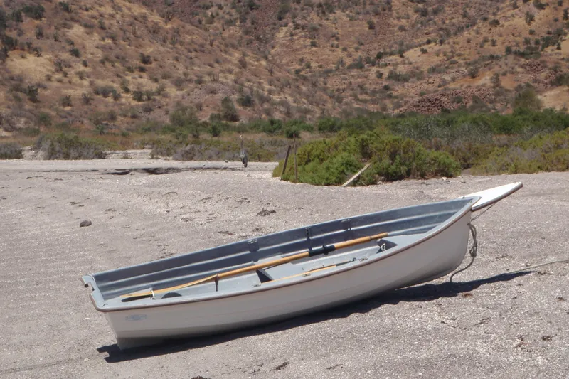 Georgia B Yacht Photos Pics Small rowboat on a sandy beach with arid hills in the background.
