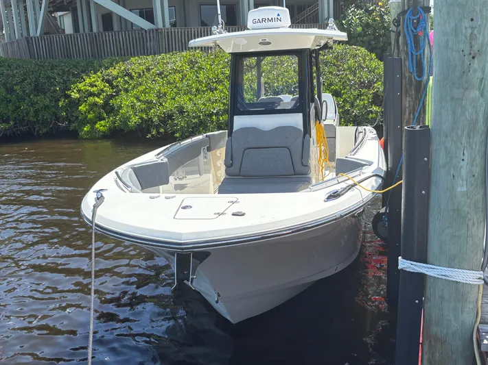  Yacht Photos Pics 2023 Stingray 273 CC boat docked, featuring Garmin equipment, in a serene waterfront setting.