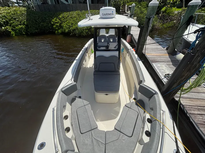  Yacht Photos Pics 2023 Stingray 273 CC boat docked, featuring spacious seating and Garmin navigation system.