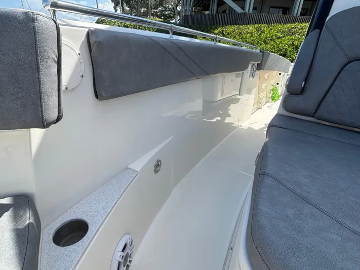  Yacht Photos Pics 2023 Stingray 273 CC boat interior with cushioned seating and cup holder.