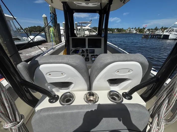  Yacht Photos Pics 2023 Stingray 273 CC boat interior with dual seats and cup holders at a marina.