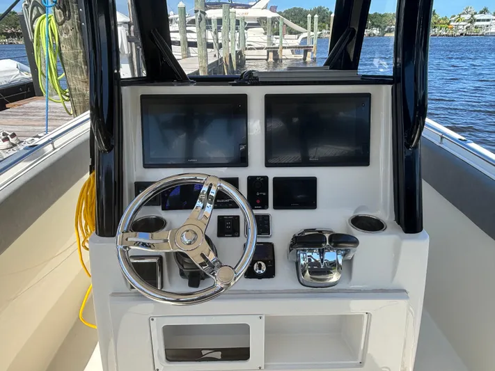  Yacht Photos Pics 2023 Stingray 273 CC boat dashboard with steering wheel and dual screens.