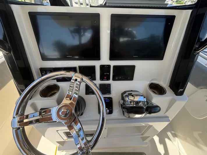  Yacht Photos Pics 2023 Stingray 273 CC boat dashboard with dual Garmin screens and chrome steering wheel.