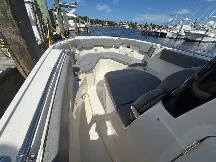  Yacht Photos Pics 2023 Stingray 273 CC boat interior with seating, docked at marina.