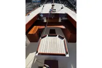 Cockpit of 2007 Latitude 46 Tofinou 7 sailboat with wooden seating and deck.