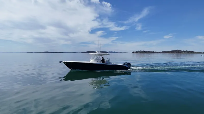  Yacht Photos Pics 2009 Edgewater 318CC boat cruising on calm, clear waters under a blue sky.