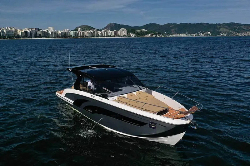 Custom Order Your 387 Today! Yacht Photos Pics 2025 Hanover 387 Inboard boat cruising on open water with cityscape in background.