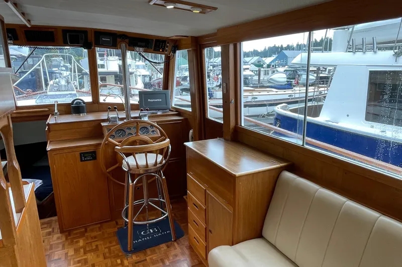 Mercator Yacht Photos Pics Interior of 1985 Grand Banks 42 Classic yacht with wooden helm and marina view.
