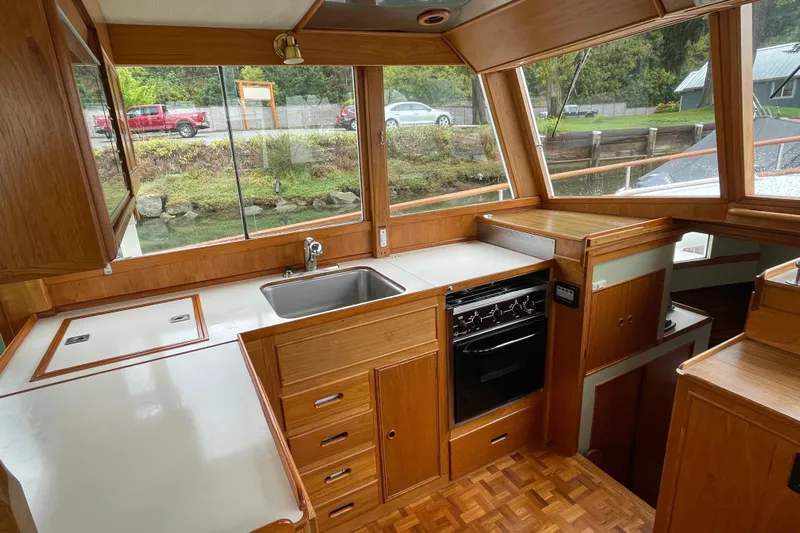 Mercator Yacht Photos Pics Interior of 1985 Grand Banks 42 Classic yacht, featuring a wooden kitchen with stove and sink.