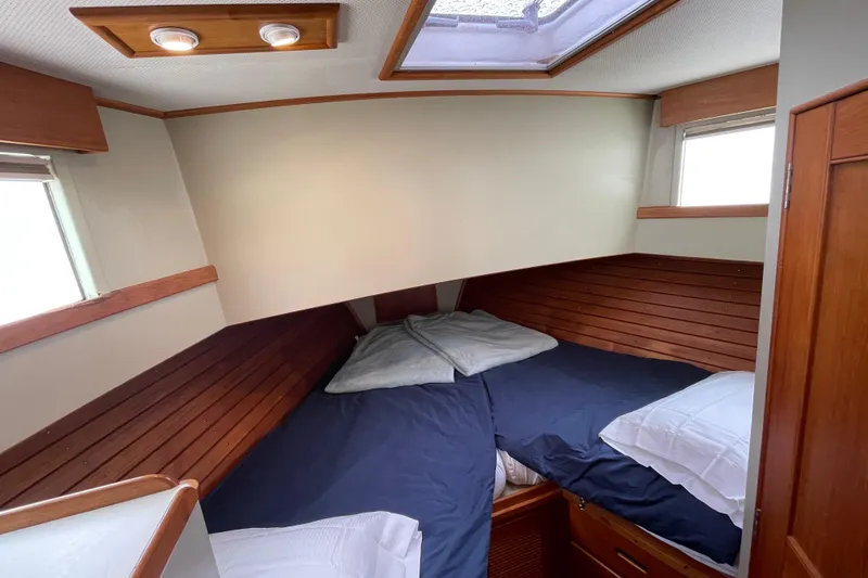 Mercator Yacht Photos Pics Cozy cabin interior of 1985 Grand Banks 42 Classic yacht with wooden accents and bedding.