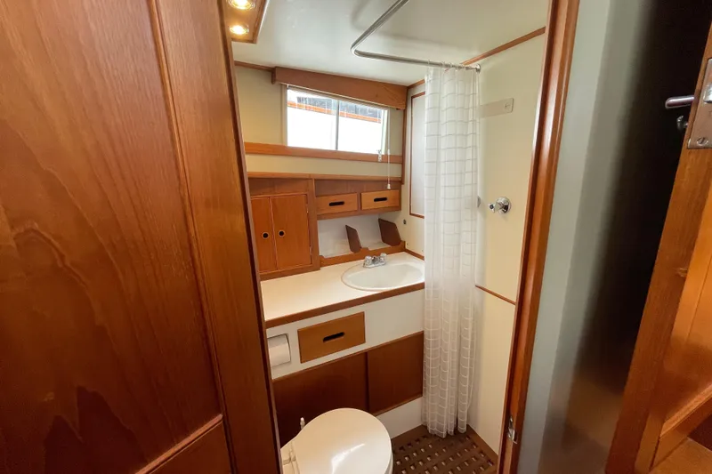 Mercator Yacht Photos Pics 1985 Grand Banks 42 Classic yacht bathroom with wood accents and shower curtain.
