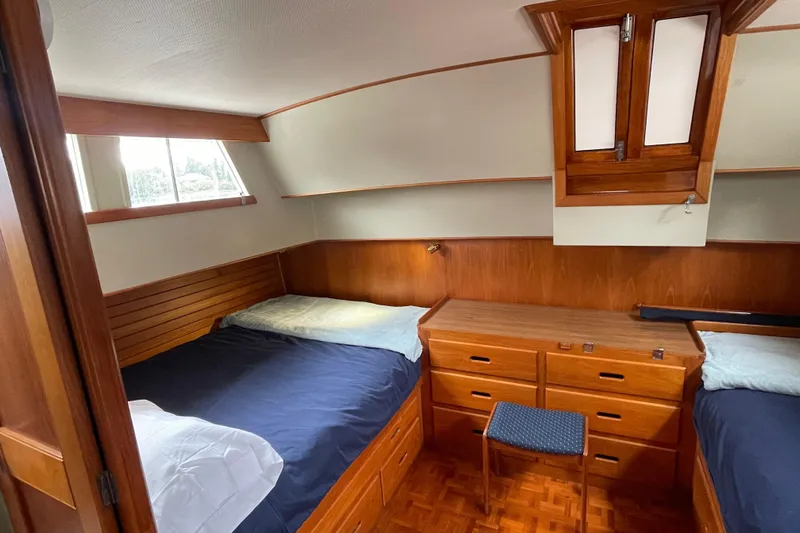 Mercator Yacht Photos Pics 1985 Grand Banks 42 Classic cabin with twin beds, wooden cabinetry, and natural light.