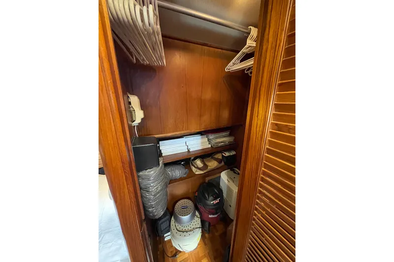Mercator Yacht Photos Pics Wooden closet interior on 1985 Grand Banks 42 Classic yacht, with hangers and storage items.