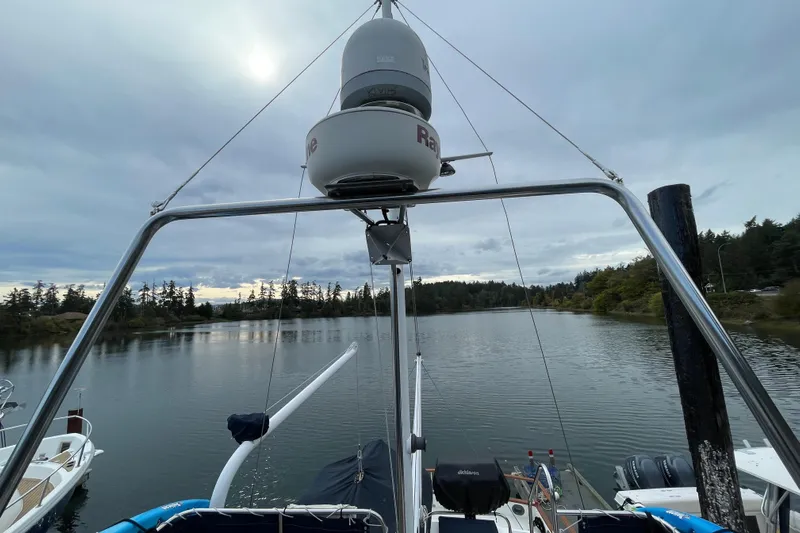 Mercator Yacht Photos Pics 1985 Grand Banks 42 Classic yacht on serene waterway, surrounded by lush trees and cloudy sky.