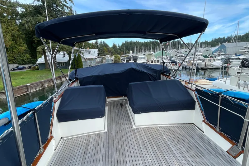 Mercator Yacht Photos Pics 1985 Grand Banks 42 Classic yacht with covered seating, docked at a marina.