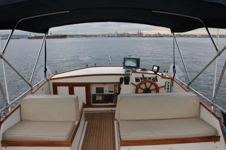 Mercator Yacht Photos Pics 1985 Grand Banks 42 Classic yacht helm with seating, overlooking calm waters and distant ships.