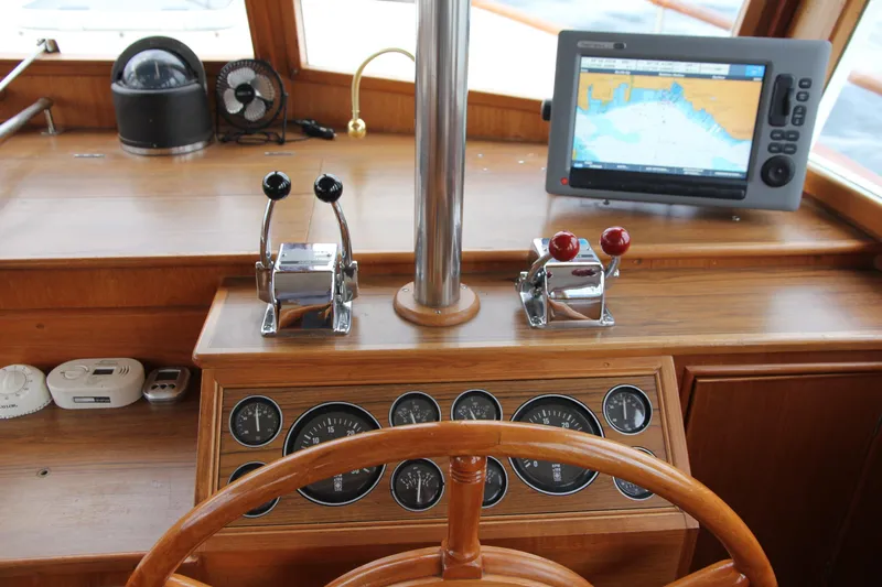 Mercator Yacht Photos Pics Helm of 1985 Grand Banks 42 Classic with navigation equipment and wooden steering wheel.
